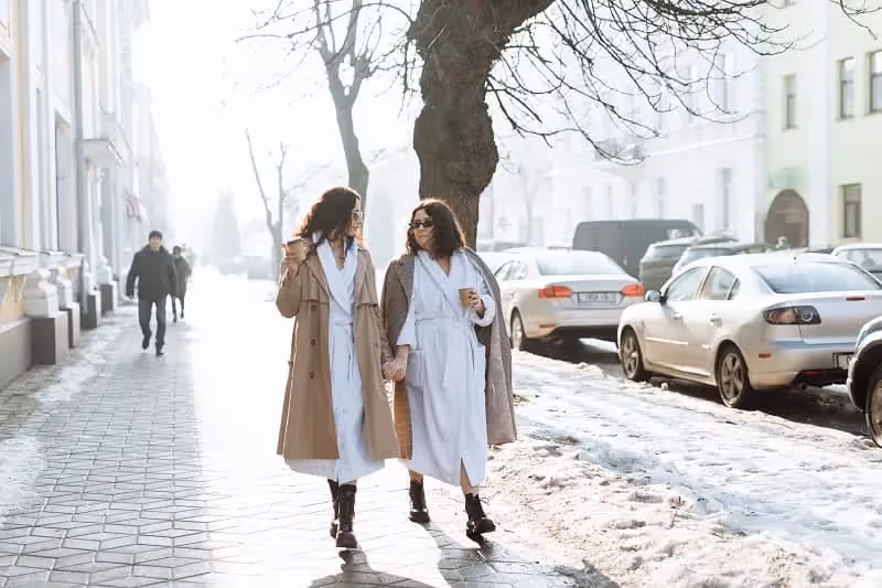 deux femmes qui marchent dans la rue en hiver car neige sur le sol