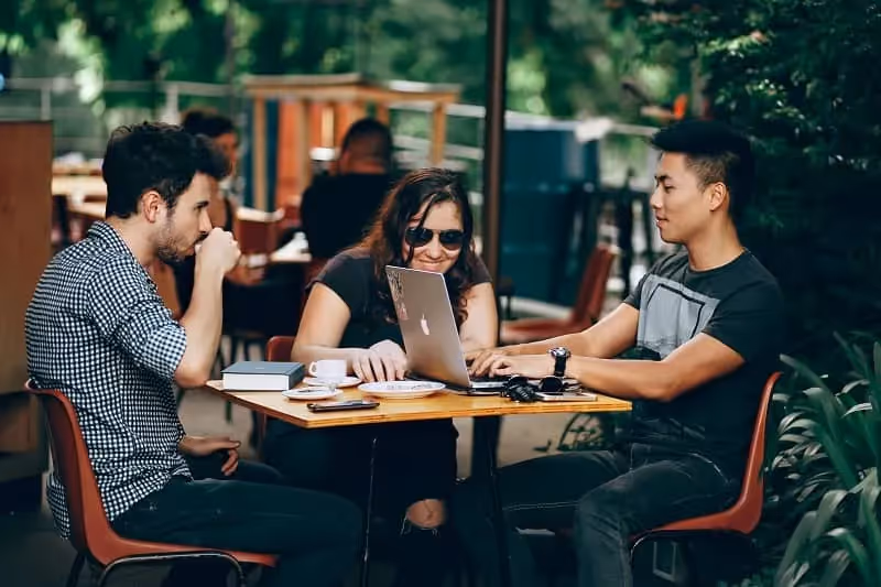 groupe d'amis qui travaille dans la terrasse d'un café