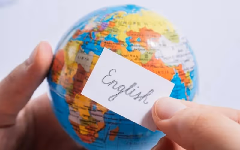 Globe de la Terre avec mot "english" écrit sur un morceau de papier entreposé contre le globe