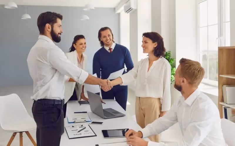 Client accueilli dans un bureau pour parler des affaires par une équipe de collaborateurs