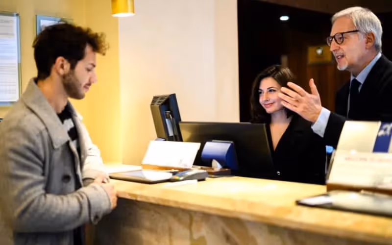 Un client qui patiente au guichet avec des employés qui lui explique quelque chose