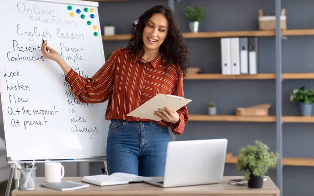 Professeure d'anglais faisant un cours d'anglais en groupe à ses élèves sur des thématiques telle que la conjugaison anglaise