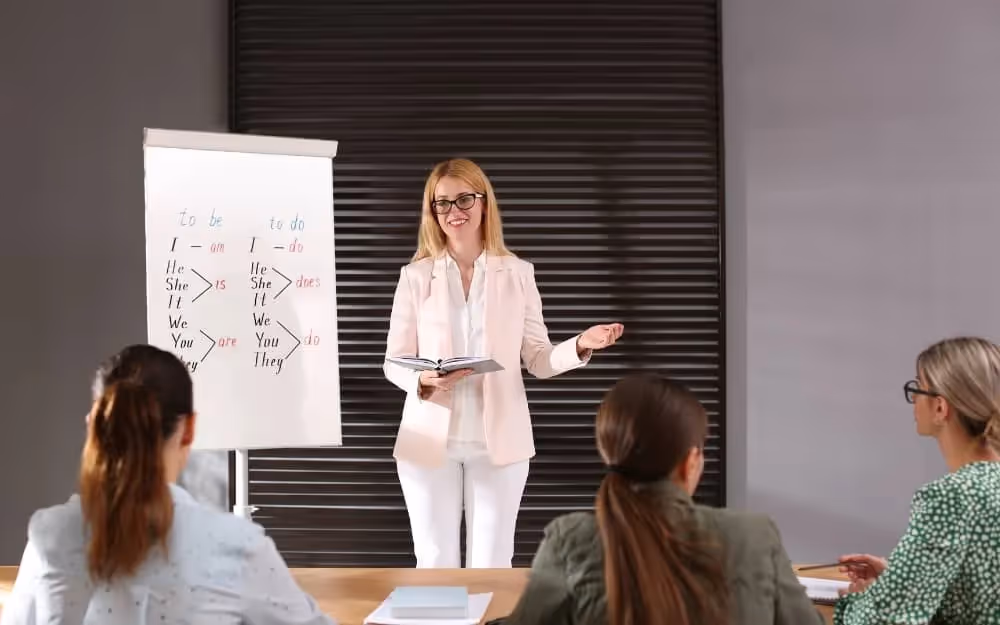 Professeure d'anglais faisant un cours d'anglais en groupe à ses élèves dans une salle