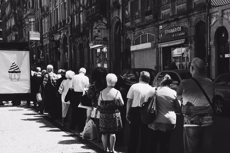image noir et blanche de personnes qui font la queue dans la rue