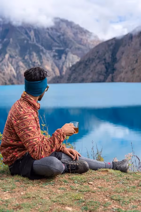 personne assise en face du lac au lake district