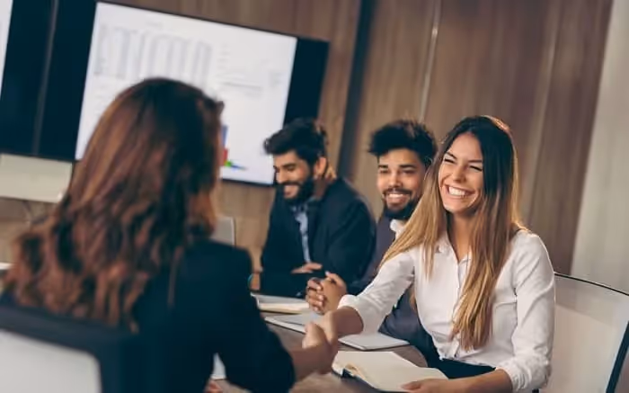 deux femmes qui se serrent la main en souriant