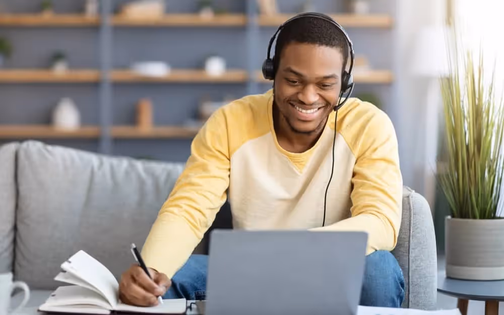 Homme suivant une formation d'anglais de chez lui pour renforcer sa confiance et son bien-être au travail