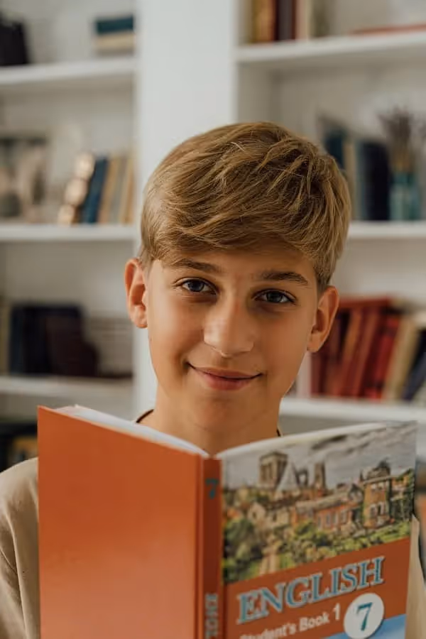 jeune garçon qui lit et étudie un livre d'anglais pour ses études