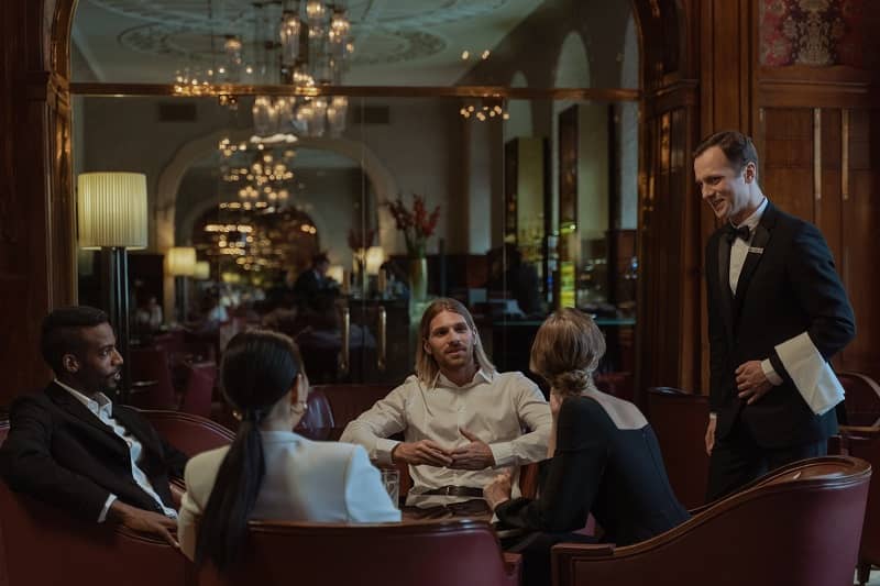 un serveur s'occupe de clients dans un restaurant de luxe