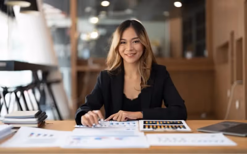 Femme qui travaille dans le secteur de la finance en anglais est assise sur son bureau