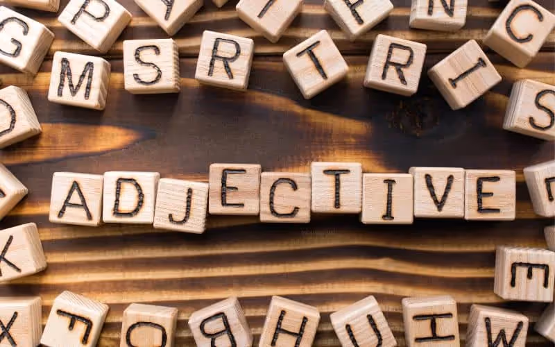le mot "adjectif" en anglais qui se traduit par "adjectives" écrit sur des cubes en bois