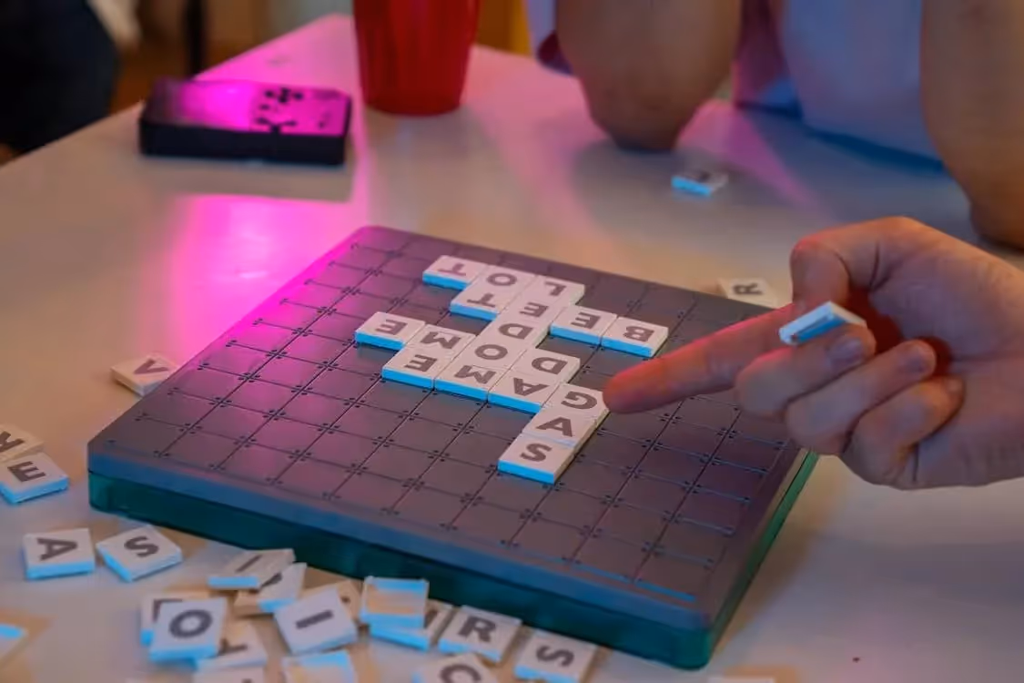 Deux personnes qui apprennent le vocabulaire de base en anglais en jouant au scrabble