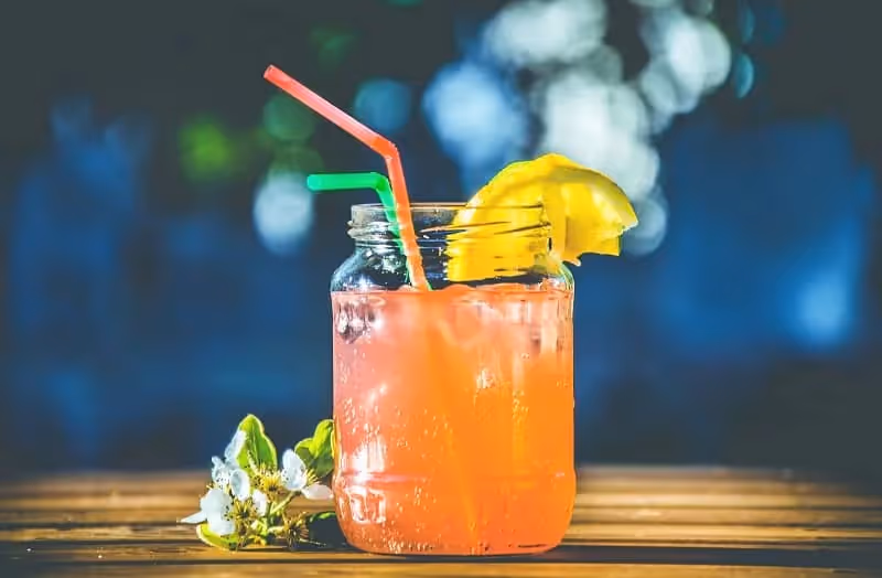 cocktail orange avec paille et fond flou