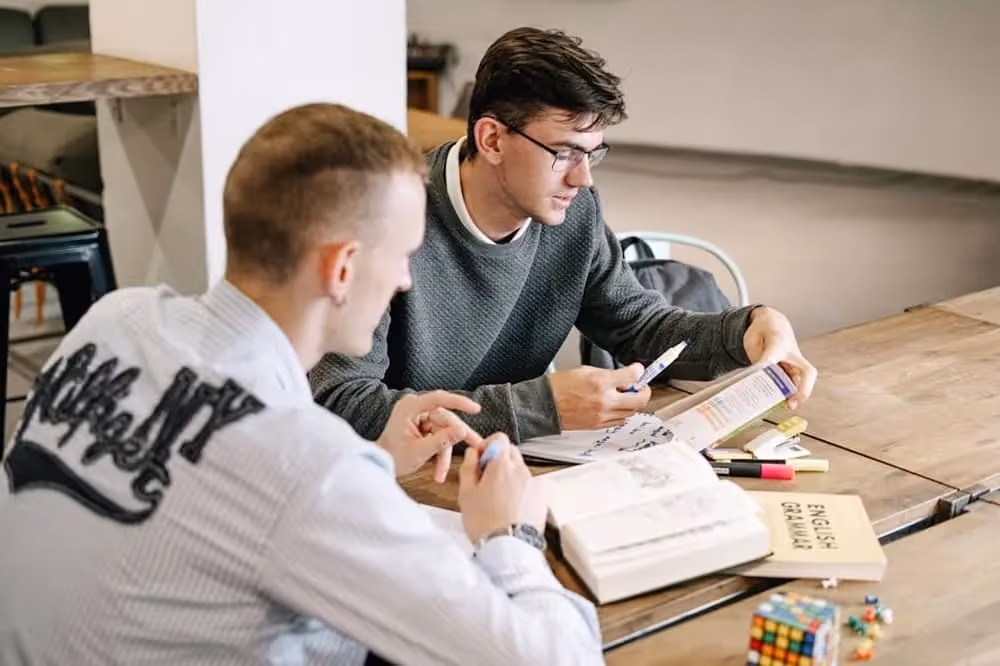 Deux étudiants qui étudient l'auxiliaire be anglais pour leur cours de grammaire anglaise