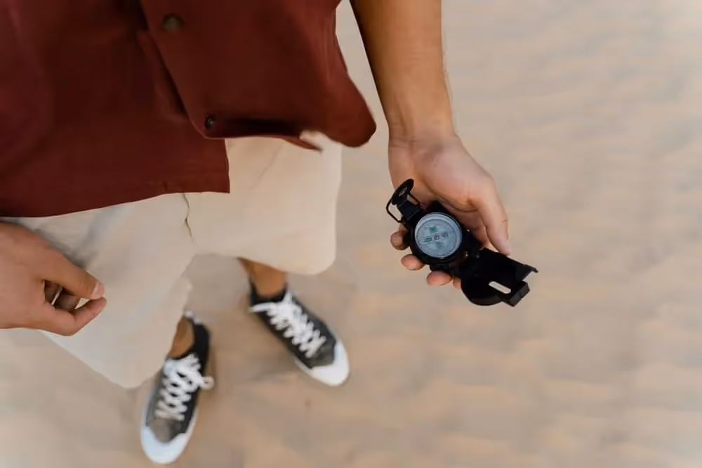 Homme regardant les points cardinaux anglais sur une boussole