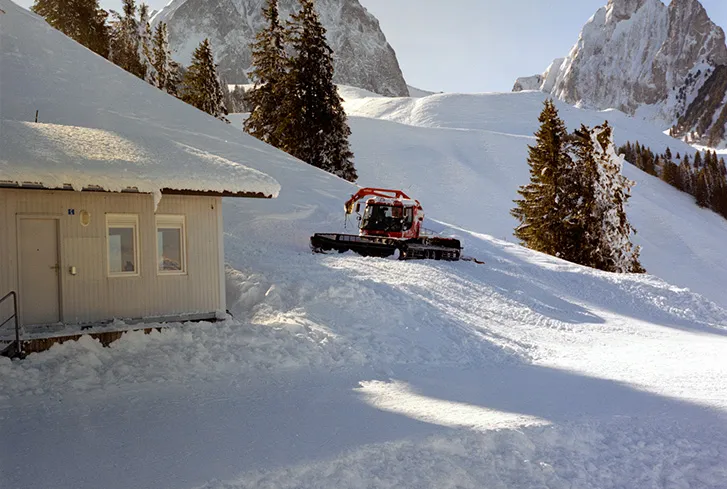 Medium-format scan of a snow-covered mountain scene and snow groomer