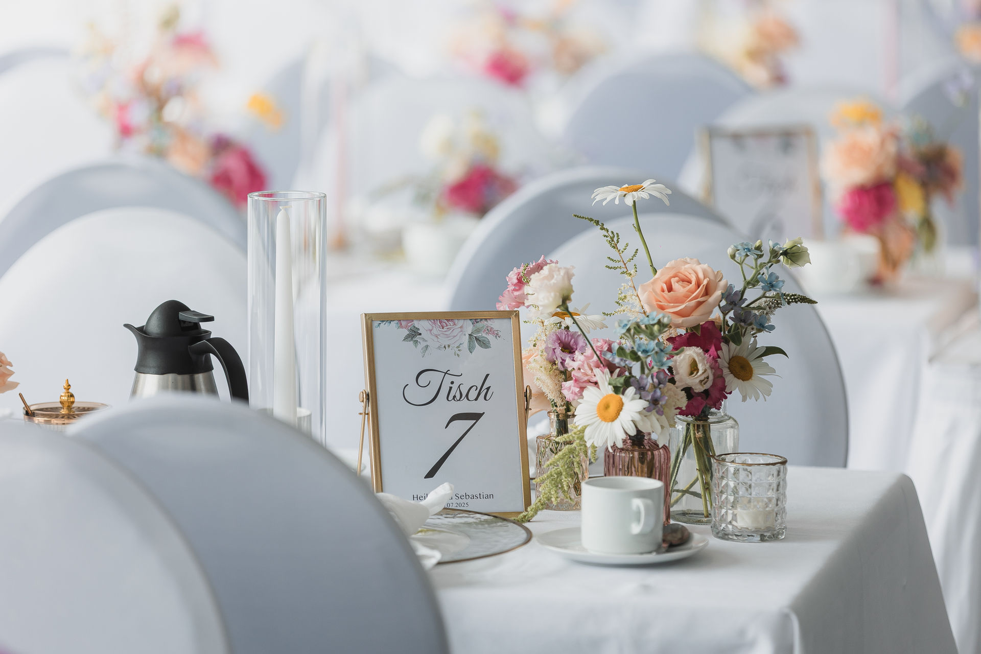 Hochzeitstisch mit Blumen, Kerzen und Tischnummern