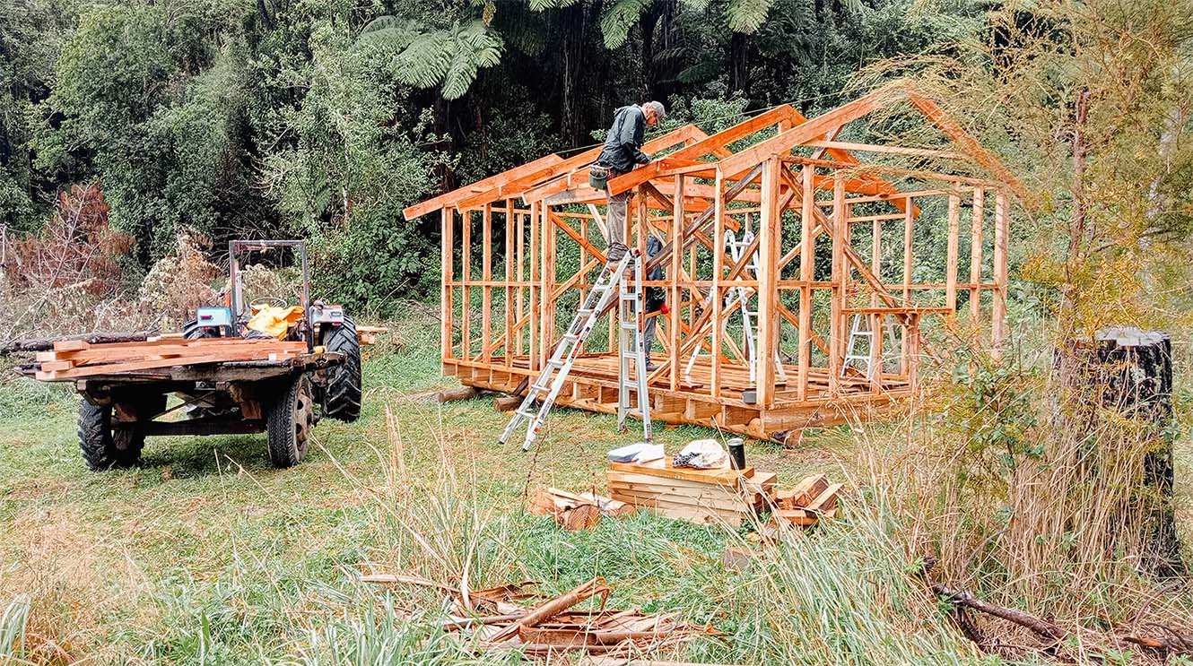 Builders working on the skeletal structure of a cabin