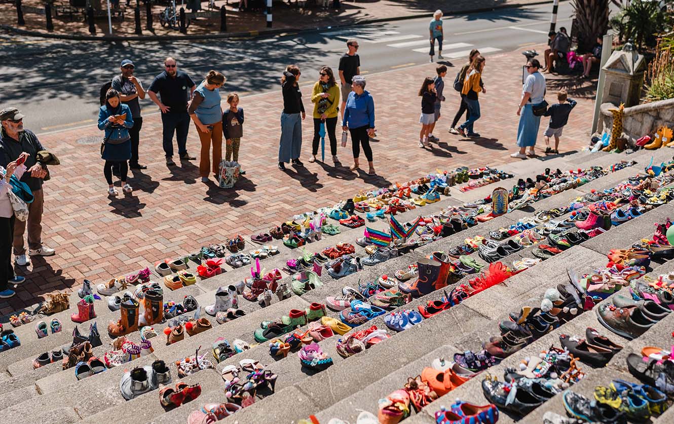 People look at shoes laid out on the cathedral steps in Nelson