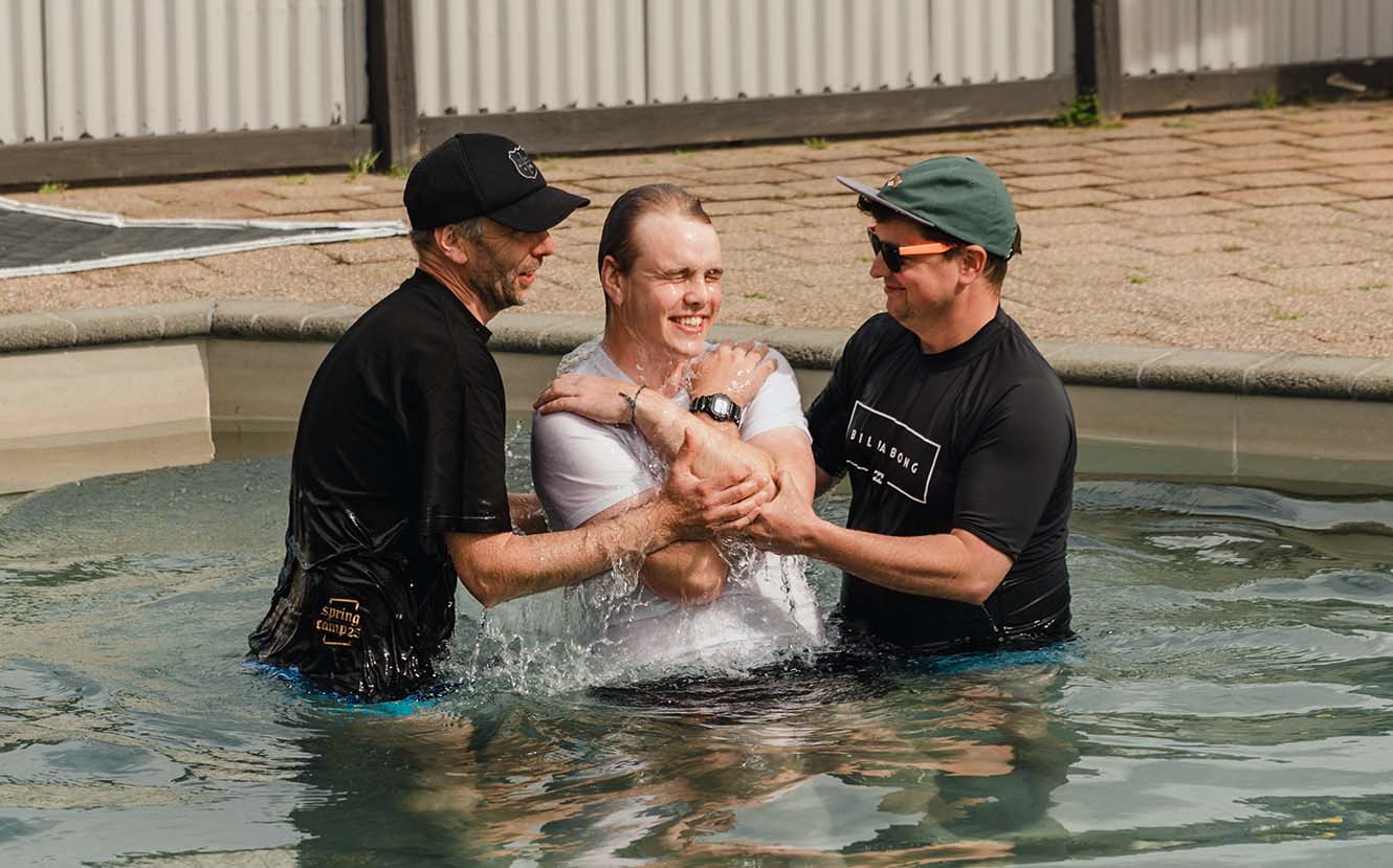 Matt Watts and Brad Wood submerging Luke Watts in the water of the pool