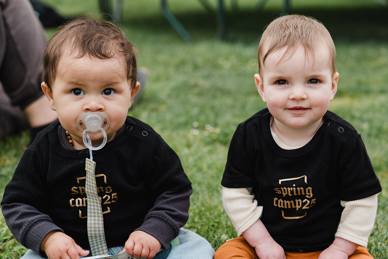 Two babies in Spring Camp 2025 shirts