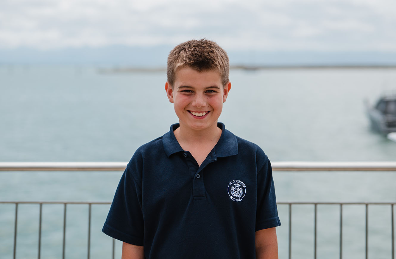 Barney smiles outside with the Nelson coast behind him