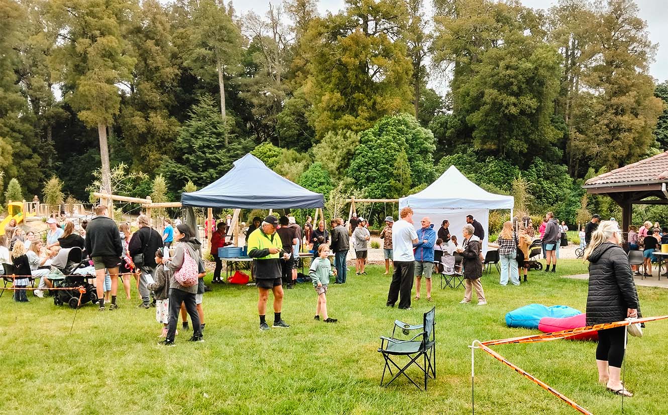 a crowd mills around Faulkner's Bush Park amidst gazebos and stalls