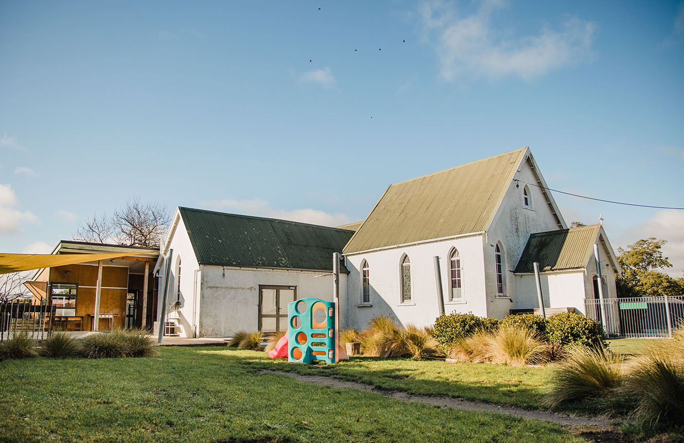Church of the Epiphany of the Awatere Christian Joint Venture (ACJV) in the Nelson Anglican Diocese. white church building in a rural area with a green lawn and playground in front.