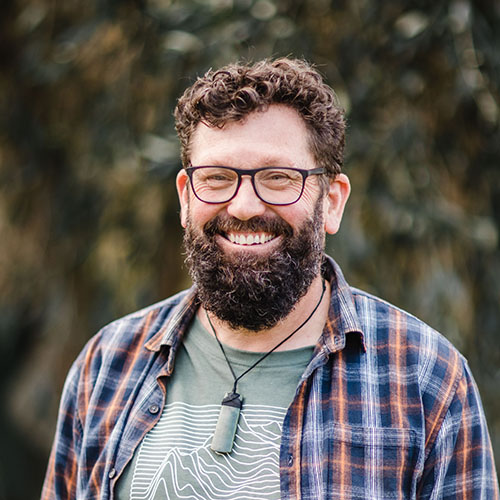 Head and shoulders of Reverend Paul Milson outside in front of some greenery