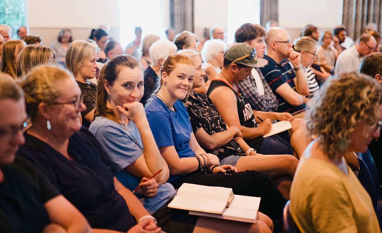 a crowd of people listen to a message given