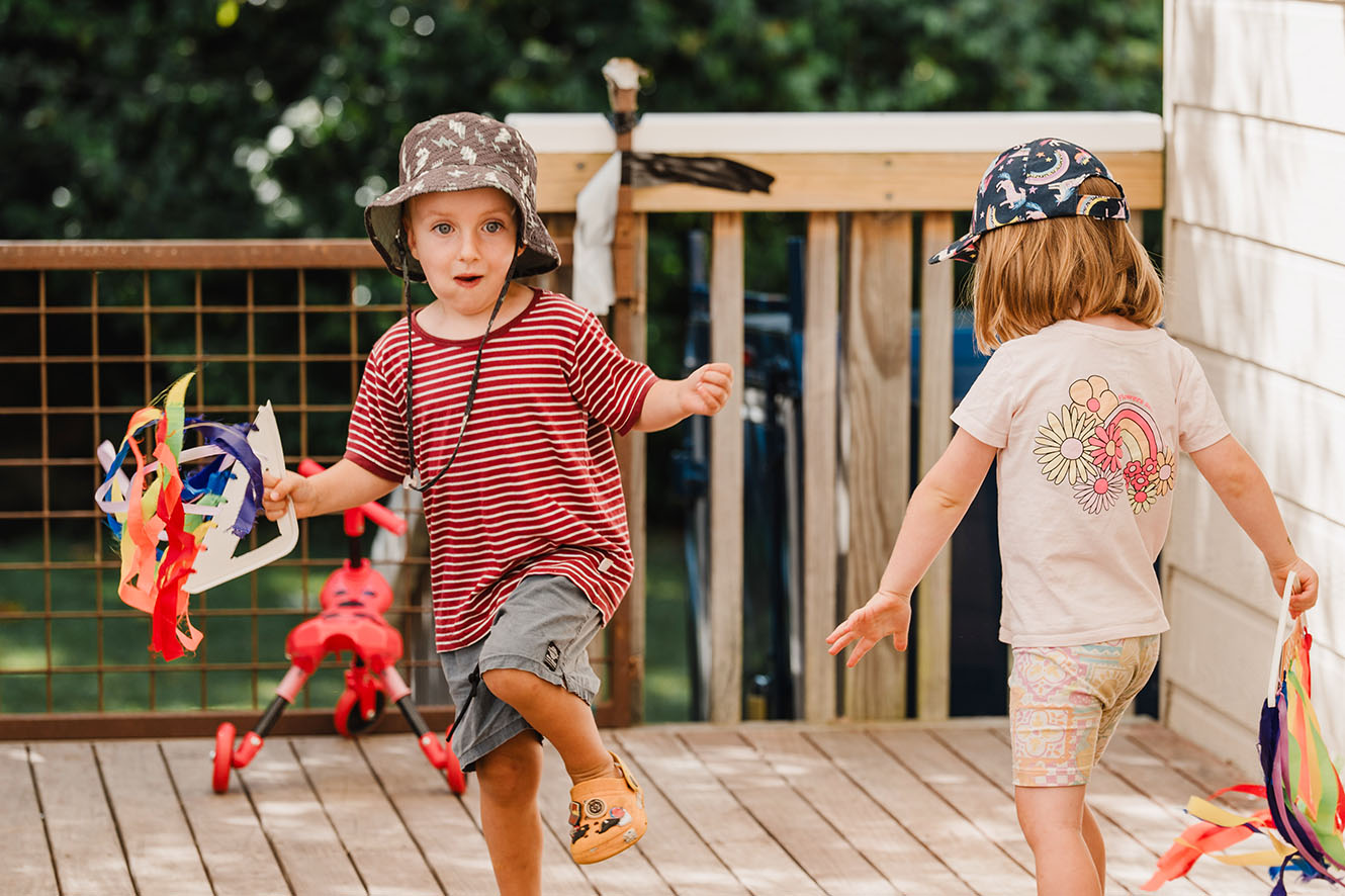 two young kids play with colourful ribbon streamers