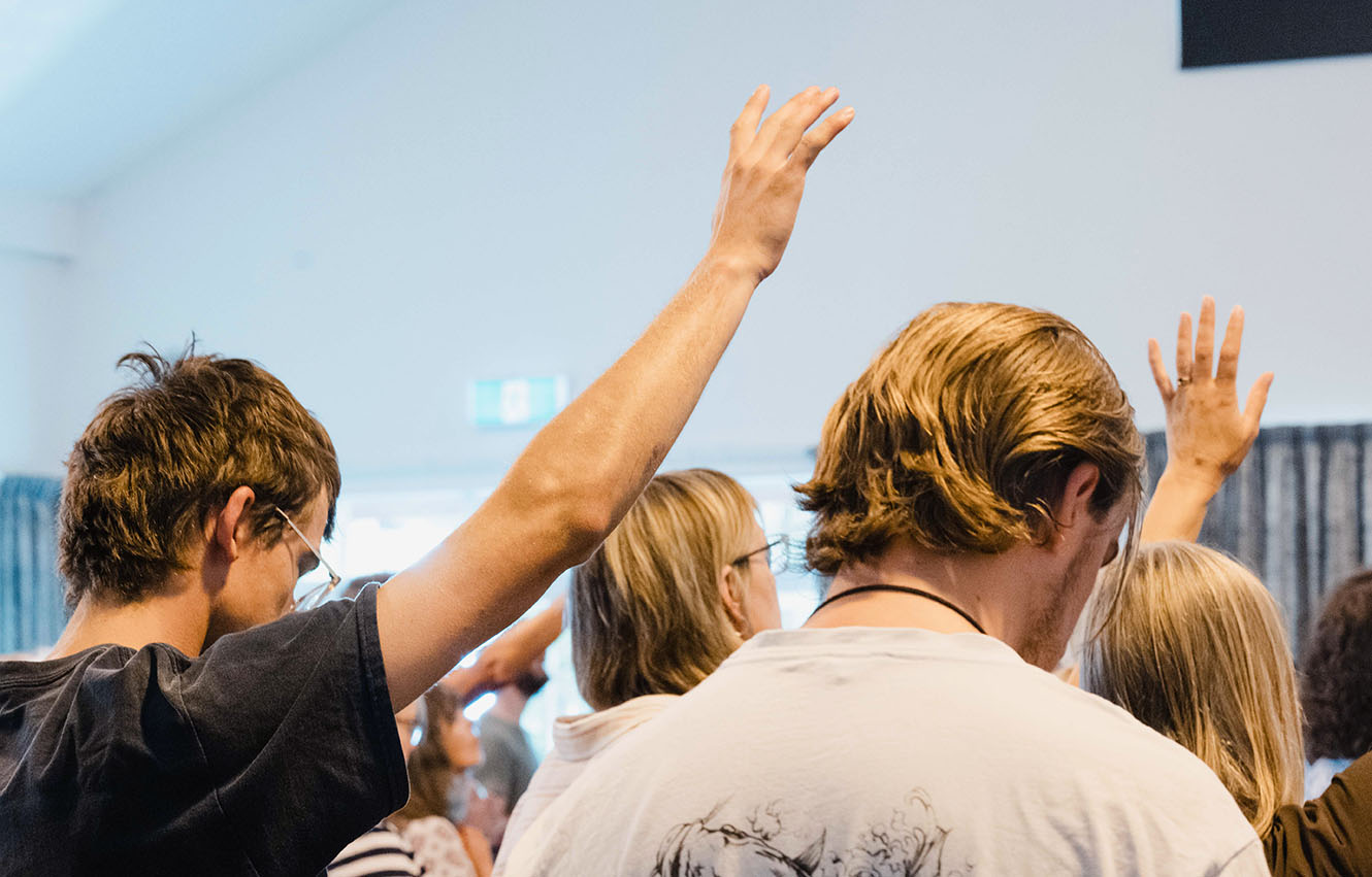 people raising arms in worship