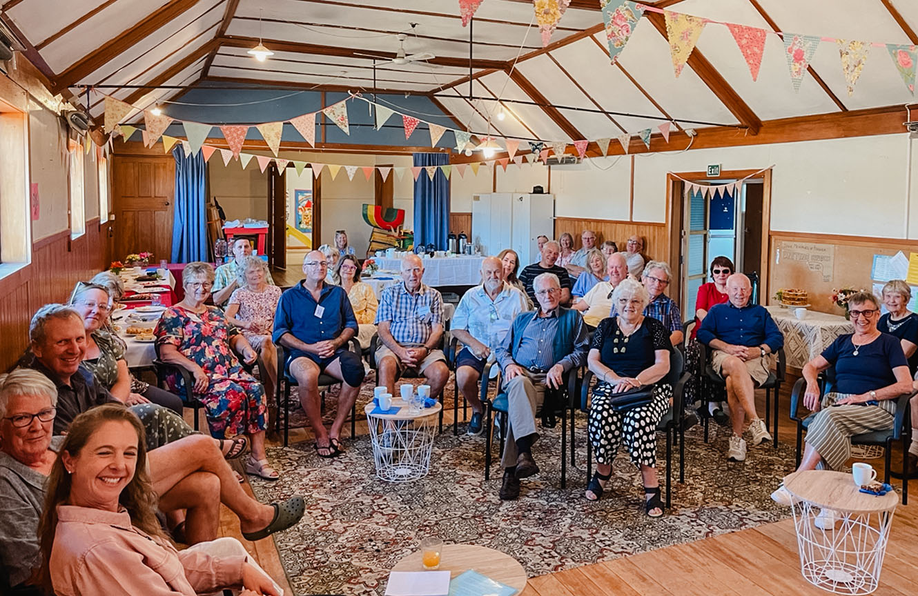 A crowd of people circled for a photo inside the old Uniting Church building.