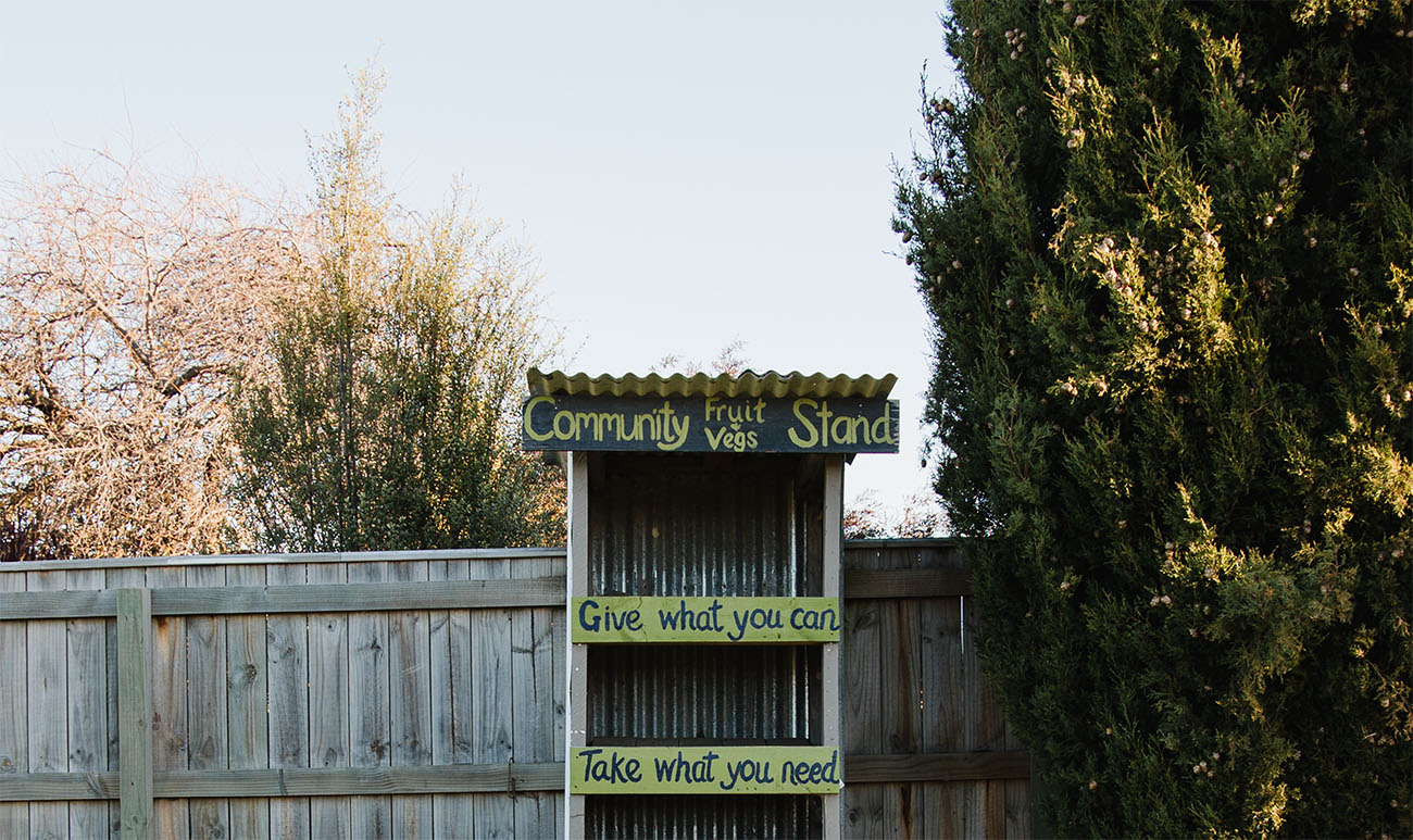 A fruit and vege stall that says "give what you can, take what you need".