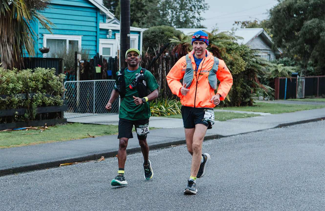 Steve Maina and Matt Watts running in Kumara on a cold wet morning