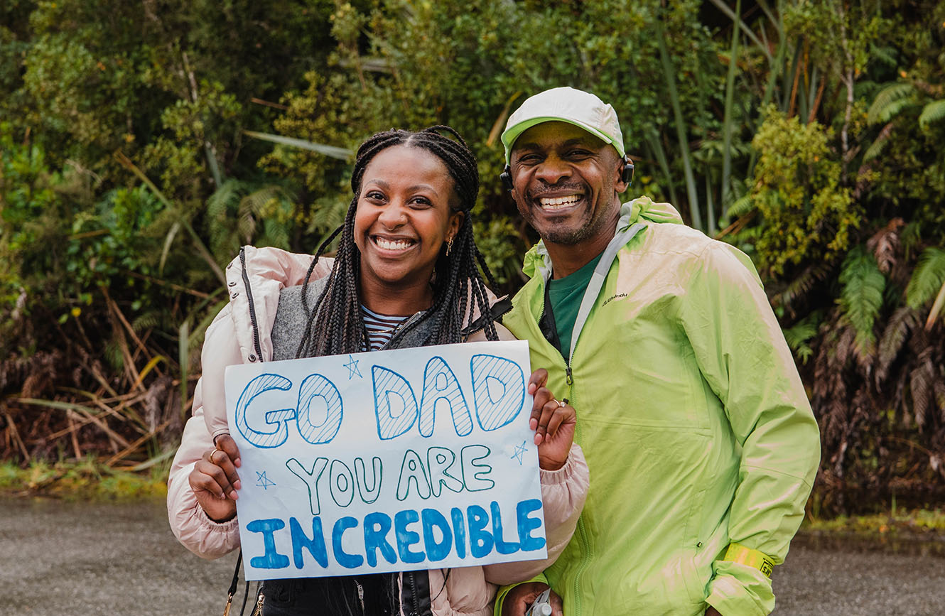 Bishop Steve with his daughter Tanielle, who holds a handmade sign that reads "Go dad, you are incredible".