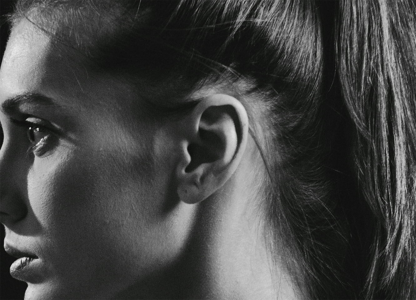a woman's head from the side, centred on her ear