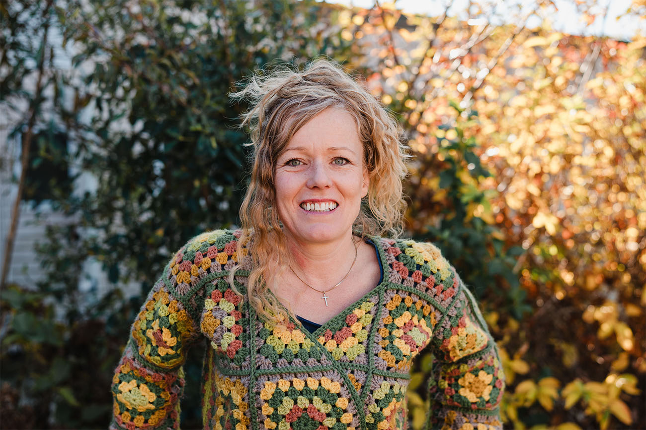A portrait of Angie outside in front of some greenery