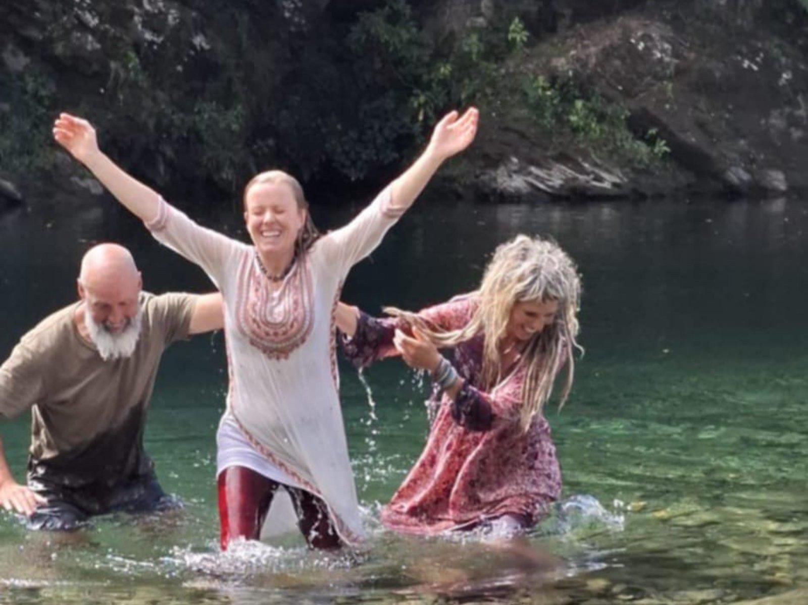 Angie being baptised in a river