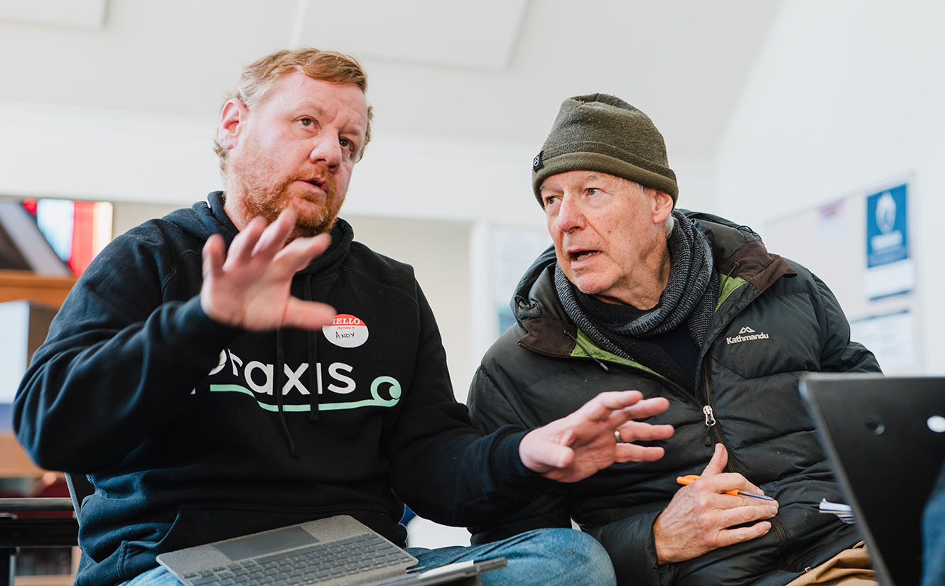 Two men talk at a workshop