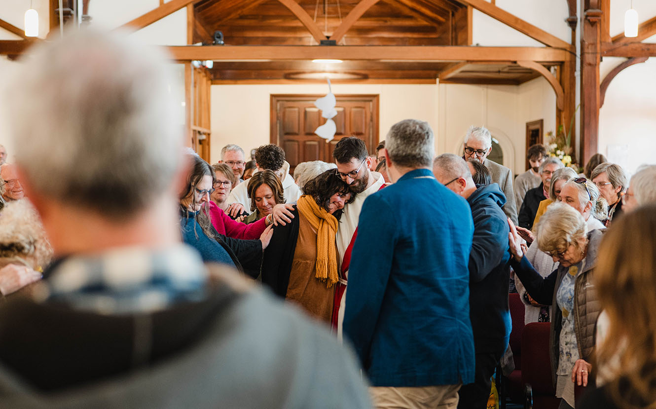 All Saints people gather around Sam and Petra Oomen in prayer