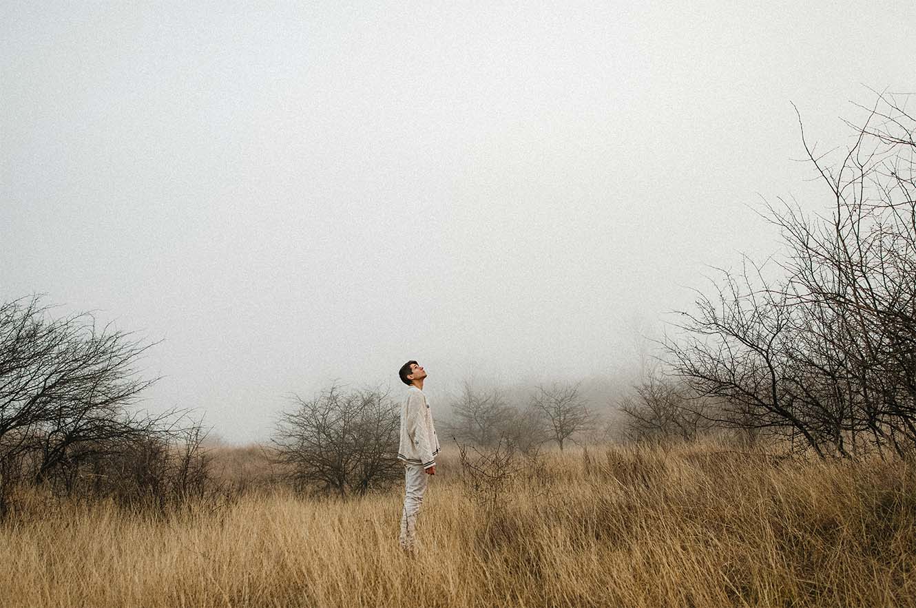 A person staring into a foggy sky