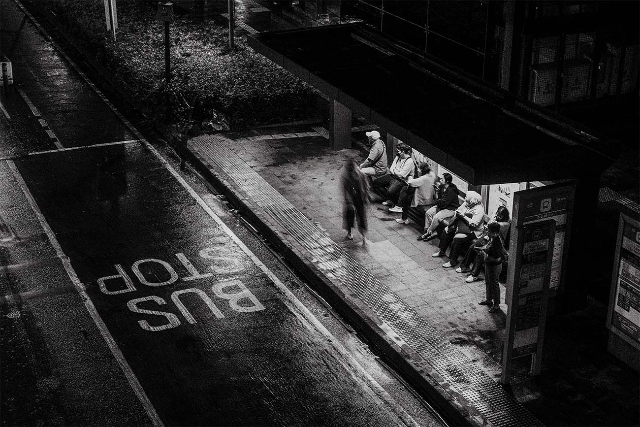 people waiting at a bus stop