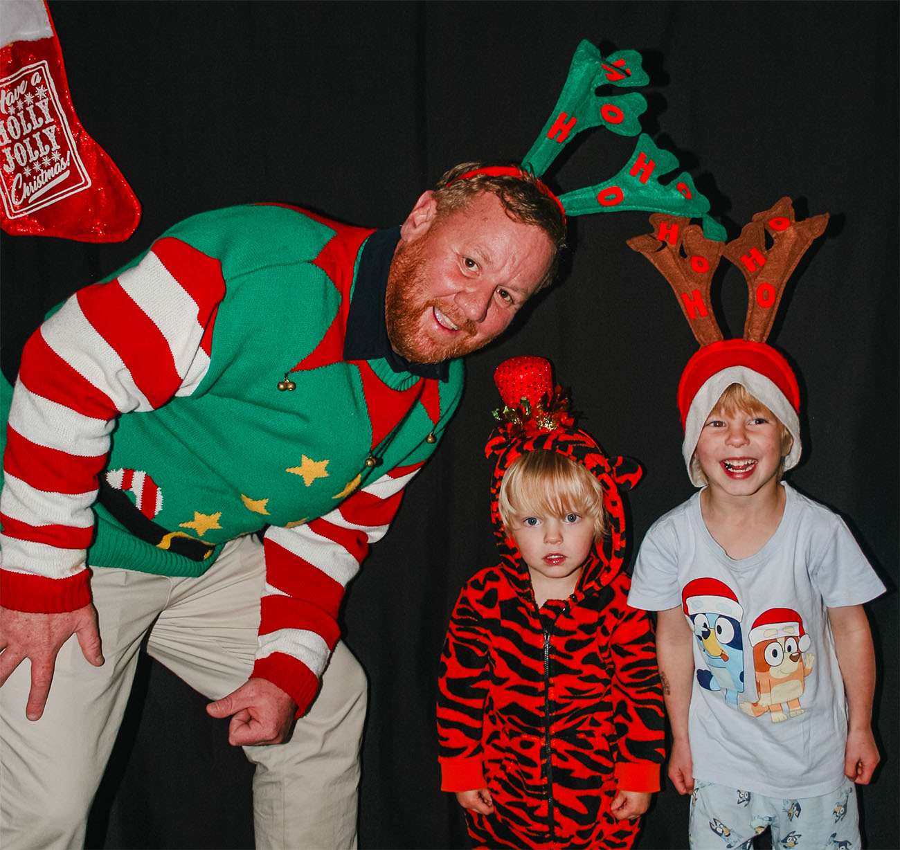 Andrew Spence and two children pose for a photo in the Christmas photobooth