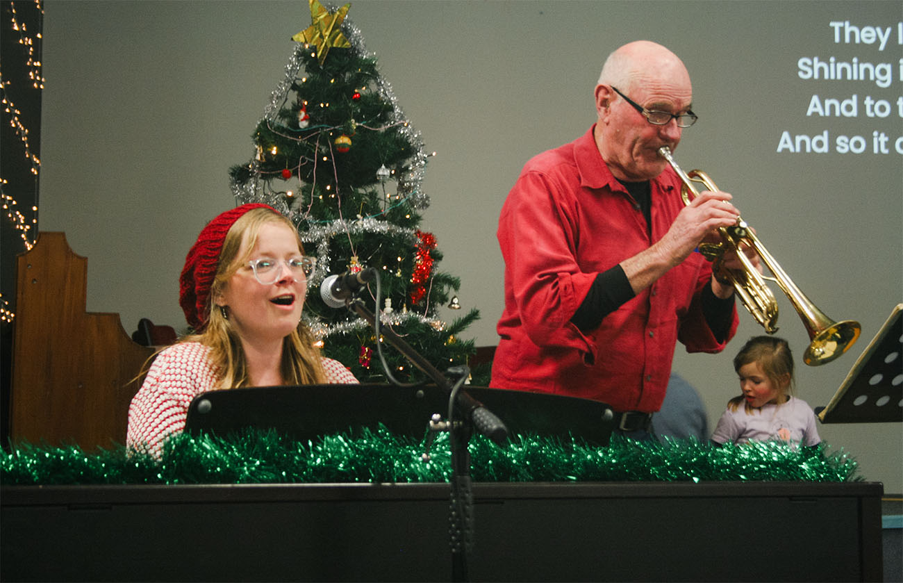 Emily Spence and a trumpeter play Christmas carols