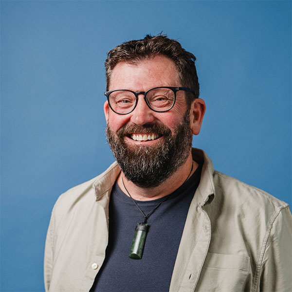 Head and shoulders of Reverend Paul Milson in front of a blue background