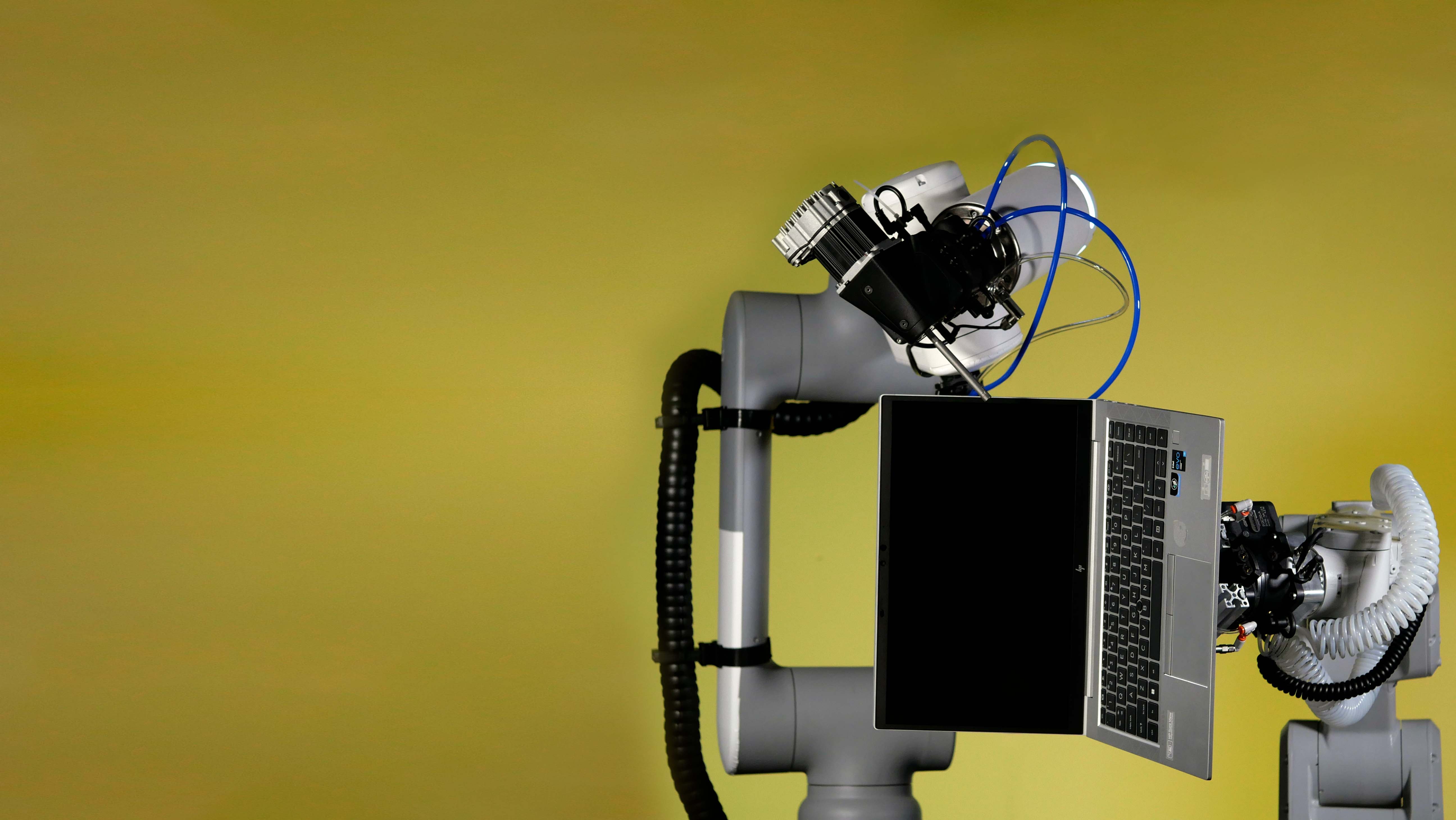 Robotic arms holding laptop