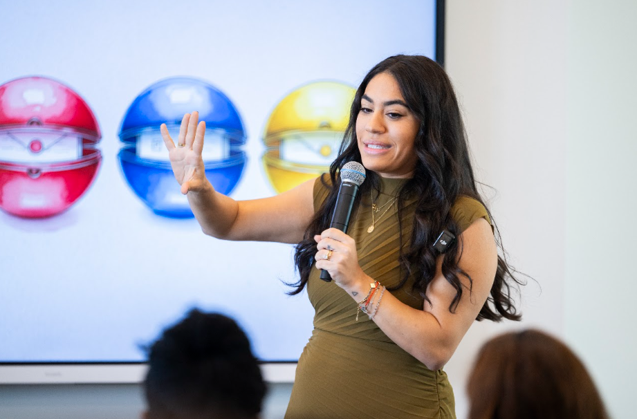 A woman speaking to a group with a microphone