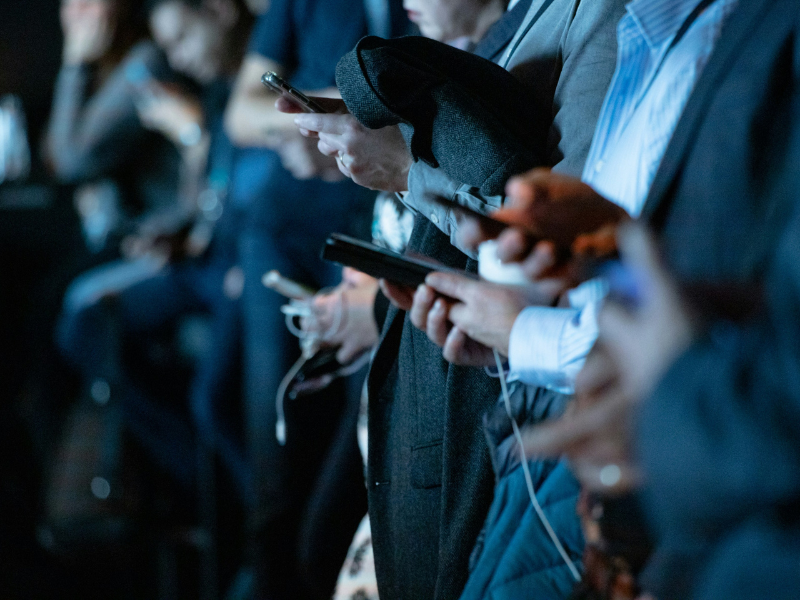 People standing in a crowd on their phones