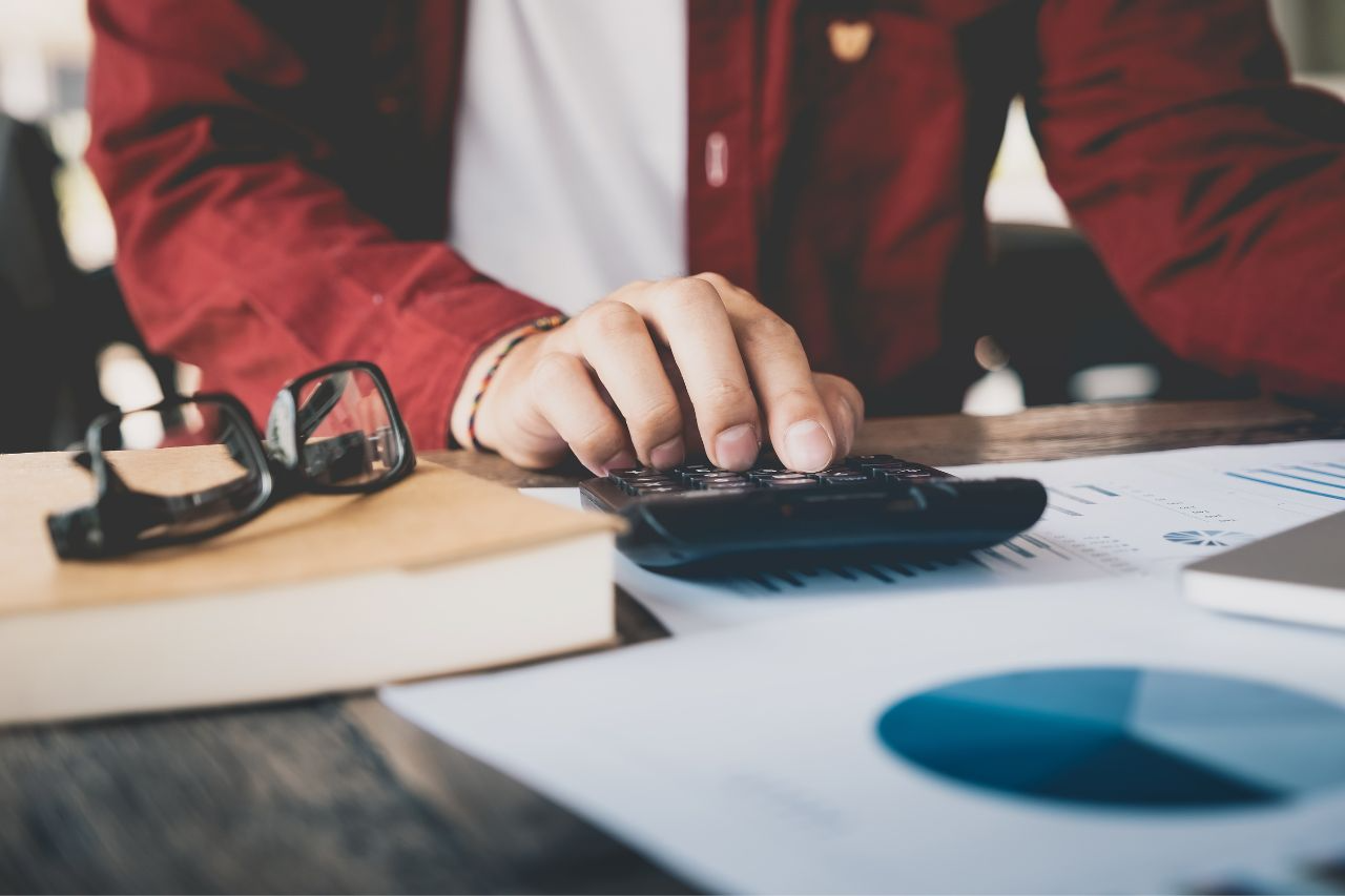 A business person using a calculator and working on a project.